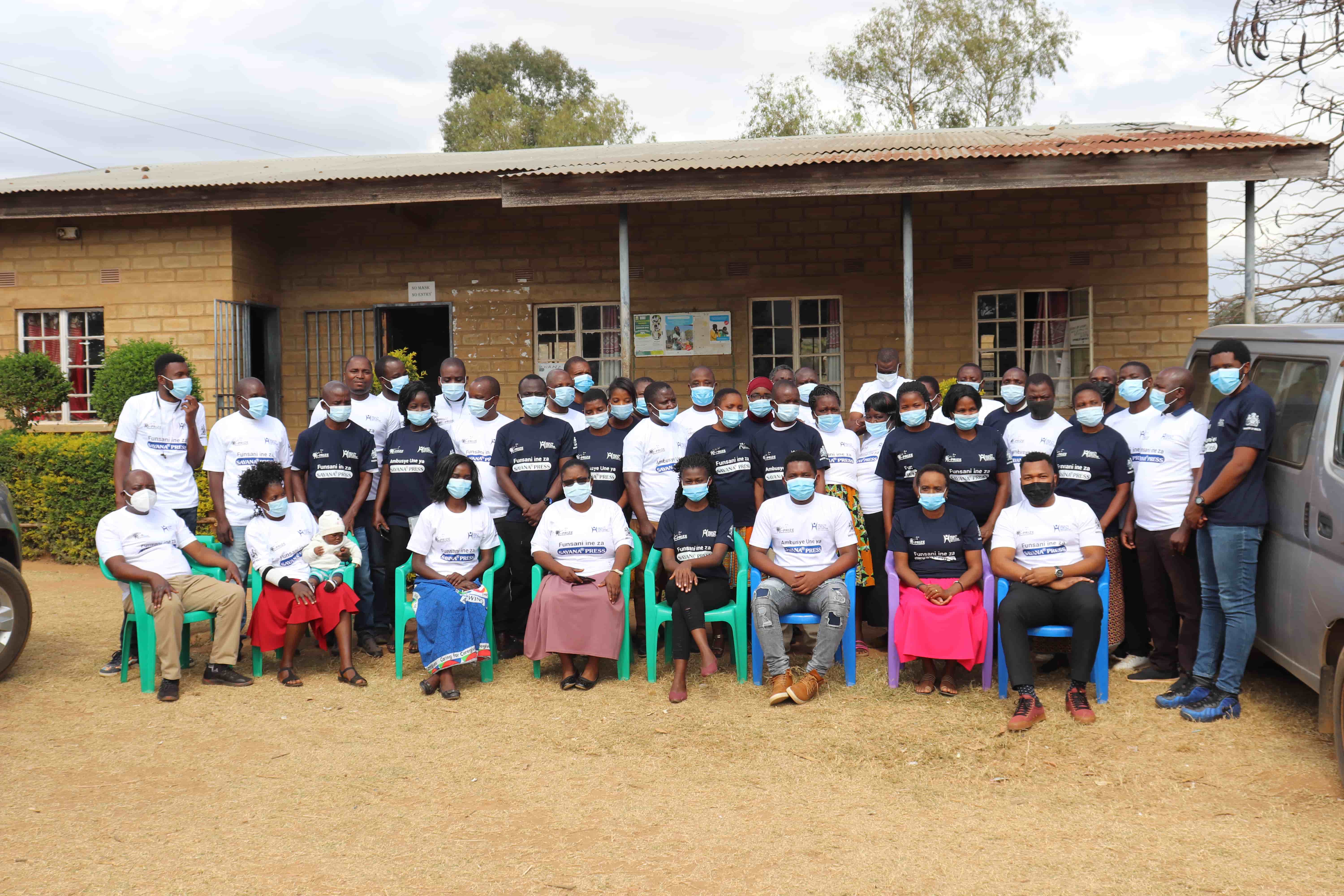 Diverse group of Malawian women smiling and interacting, symbolizing community and health.